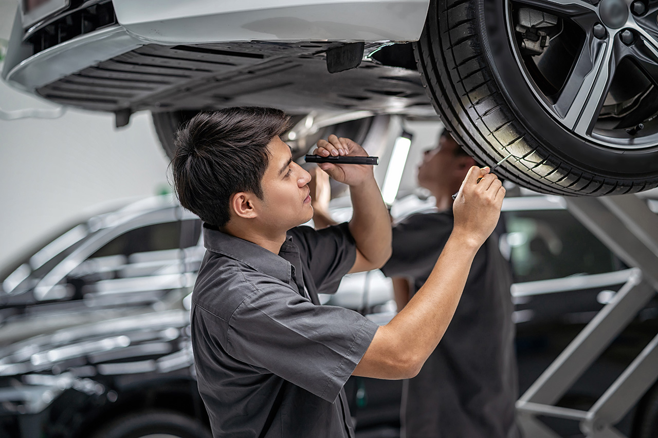 Mechanic inspecting tires during a Chevy service appointment