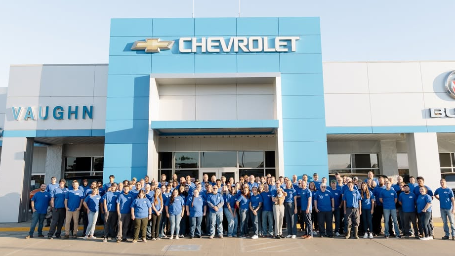 Vaughn Automotive Chevrolet dealership happy team members outside of storefront in Ottumwa Iowa